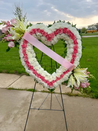 Heart Shaped Funeral Wreath | A Gorgeous Pink and White Fresh Flower Tribute, in an Open Heart Concept. Arranged with the Freshest Roses, Carnations, and Lilies and displayed on an easel stand during Celebration of Life and Funeral Services to Pay Tribute to a Loved One. A Perfect Heart Display for a Mother, Daughter, Sister, or Grandmother. Your Local Funeral Florist Country Charm Floral and Gifts delivers to all funeral homes and churches throughout LaPorte County, IN- 7 Days a Week.