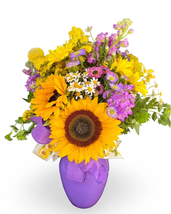 Country Charm Floral and Gifts | Florist LaPorte Indiana Purple Sunburst Bouquet: A fresh-cut flower arrangement of assorted purple and yellow vibrant flowers. This stunning bouquet will surely make your loved one's day, with its beautifully rich purple Asters, Button Mums, and Gladiolus paired with uplifting yellow Sunflowers, Daisies, and Mums in a glossy purple glass vase. Send our Purple Sunburst Bouquet to anyone who could use a pick-me-up at work, has a birthday/anniversary to celebrate, or even send this gift as a beautiful get well soon bouquet. LaPorte, Indiana Top Florist Open 7 Days a Week.