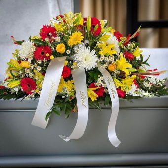 Our Casket Spray for Him is an elegant and masculine fresh flower tribute, composed of premium red, yellow, and white fresh cut flowers, and displayed atop the casket during a funeral service, memorial service, visitation, or celebration of life. A tasteful floral display to convey a message of love and respect to a loved man in your life. LaPorte, Indiana Florist for all occasions, delivery 7 days a week to homes, businesses, and funeral homes daily.