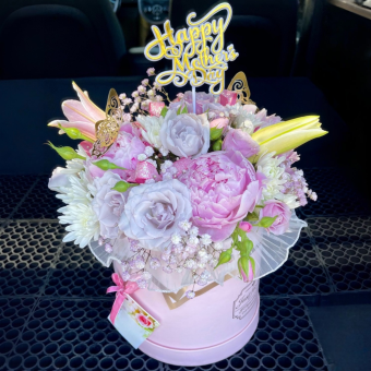 gorgeous gift bouquet - a tasteful round, gift hat box filled with only premium pink and purple flowers including roses, lilies, carnations, mums, and beautiful accent flowers. this gorgeous gift box bouquet makes for the best mothers day gift!